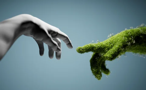 marble statue hand reaching out toward green hand covered in plants with index fingers nearly touching